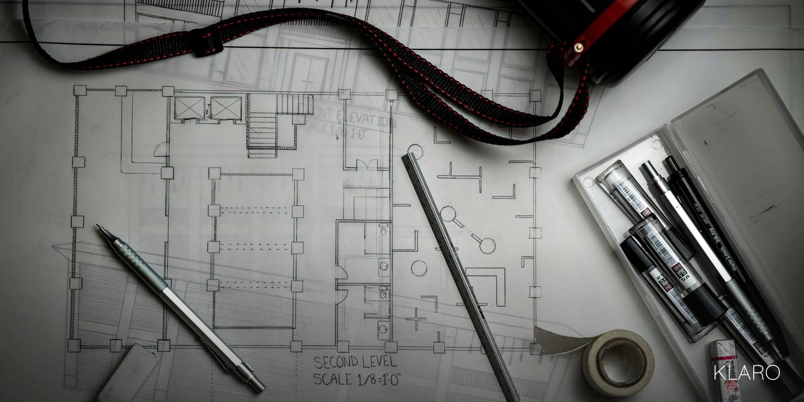 Bouwtekeningen met tekengereedschap op een bureau
